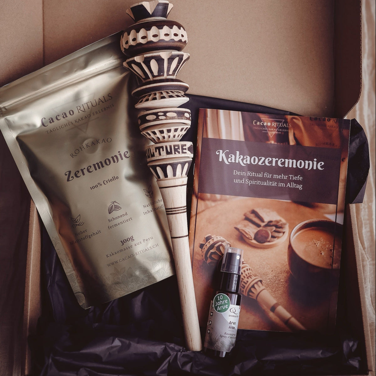 Geöffnete Kakaozeremonie Geschenkbox: Rohkakao Zeremonie, ein Molinillo, Booklet und Arve-Aromaspray
