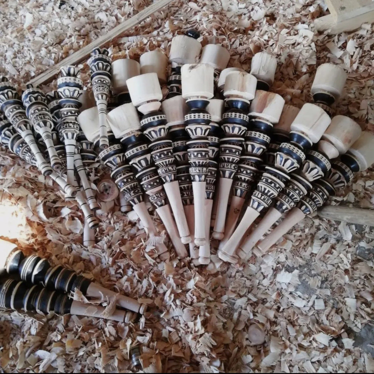 Fertig geschnitzte Molinillos in Holzspänen in der Werkstatt